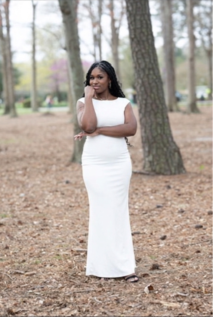 Aleaha, founder of A Crown of Beauty, standing in a white dress among trees